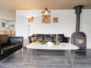 een woonkamer met een tafel en een open haard bij Holiday Home Kolle - 3-2km from the sea in Bornholm by Interhome in Vester Sømarken