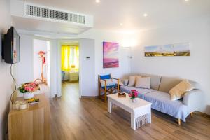 ein Wohnzimmer mit einem Sofa und einem Tisch in der Unterkunft Apartamento Buganvilla B5 in Son Bou