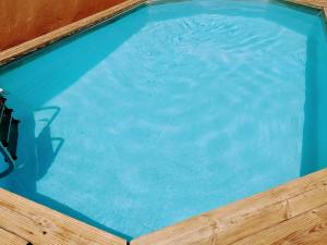 una piscina de agua azul en un marco de madera en Les Gîtes de Cayenne - Gîte Olivia en Uzès