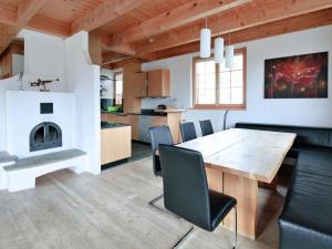 una cucina e una sala da pranzo con tavolo e sedie in legno di Apartment Chalet Selina by Interhome a Lenz