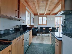 uma cozinha com bancadas pretas e uma sala de jantar em Apartment Chalet Selina by Interhome em Lenz
