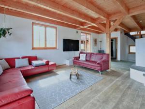 uma sala de estar com sofás vermelhos e uma televisão de ecrã plano em Apartment Chalet Selina by Interhome em Lenz