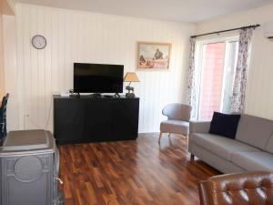 a living room with a couch and a flat screen tv at Holiday Home Anneks by Interhome in Sørbø