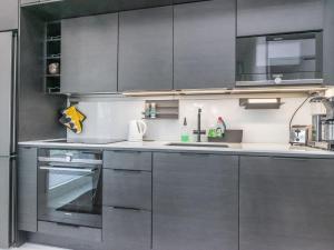 una cocina con electrodomésticos de acero inoxidable y armarios grises en Holiday Home Kuortaneen helmi by Interhome, en Kuortane