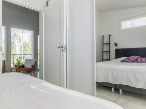 a white bedroom with a bed and a window at Holiday Home Kuortaneen helmi by Interhome in Kuortane