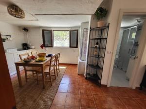 a kitchen and dining room with a table and chairs at Casa Rural LOS PINARES El Juncal de TEJEDA in Tejeda