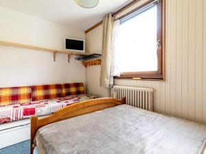 een kleine slaapkamer met een bed en een raam bij Apartment Les Genepis-7 by Interhome in Tignes
