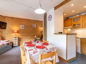 een keuken met een tafel met rode borden erop bij Apartment Les Genepis-7 by Interhome in Tignes