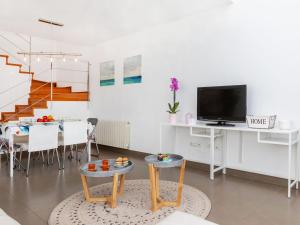 a living room with a table and a tv at Holiday Home Pijoan by Interhome in Sant Antoni de Calonge