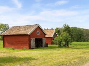 ビンメルビューにあるHoliday Home Skogstorpet - SND049 by Interhomeの古い赤い納屋が畑に座っている