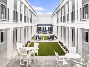 a courtyard with tables and chairs in a building at stayAPT Suites North Charleston in Charleston