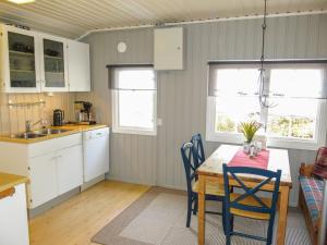 uma cozinha com uma mesa e cadeiras numa cozinha em Chalet Engelbu - SOW141 by Interhome em Fossdal