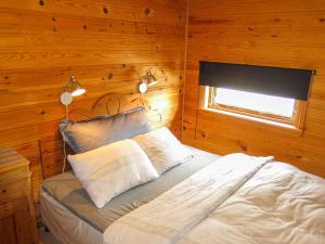 um quarto com uma cama num quarto com paredes de madeira em Chalet Engelbu - SOW141 by Interhome em Fossdal