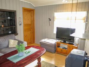 uma sala de estar com um sofá e uma televisão em Chalet Engelbu - SOW141 by Interhome em Fossdal
