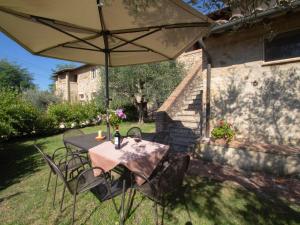 uma mesa e cadeiras debaixo de um guarda-sol num quintal em Holiday Home Tenuta Le Beringhe by Interhome em Colle Val D'Elsa