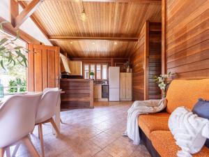 uma sala de estar com um sofá e uma cozinha em Chalet Tropical 2 by Interhome em Riumar