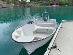 een witte boot geparkeerd bij een dok in het water bij Holiday Home Villa Hjartnes - FJH676 by Interhome in Hjartåker