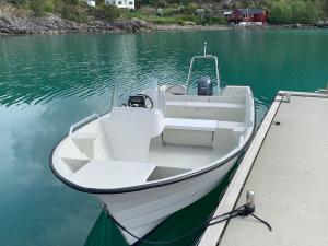 a white boat parked at a dock in the water at Holiday Home Villa Hjartnes by Interhome in Hjartåker