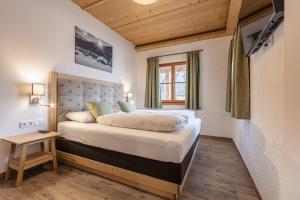 a bedroom with a large bed and a window at Premium Tauernstyle Golling in Mariapfarr