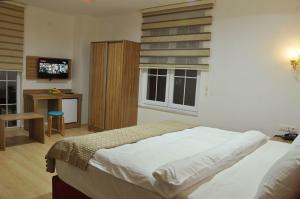 a bedroom with a bed and a television in it at Grand Beyaz Saray Otel in Duzce