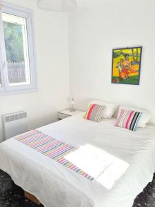 a white bed in a white bedroom with a window at La Med in Carry-le-Rouet