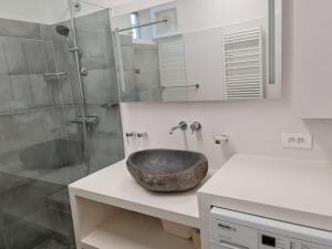 a bathroom with a stone sink and a shower at La Med in Carry-le-Rouet
