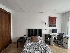 - une chambre avec un lit et un bureau avec un ordinateur dans l'établissement Seaside - Luxury Living, à Dar Bouazza