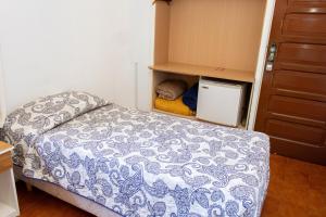 um pequeno quarto com uma cama e um armário em Hotel Fazenda Poços de Caldas em Poços de Caldas