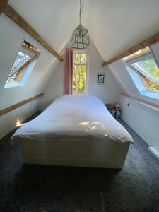 1 dormitorio con 1 cama blanca en el ático en Tiara, en Zierikzee