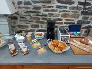 布列塔尼多勒的住宿－Manoir de l'Angélus，餐桌,包括面包、羊角面包和其他食物