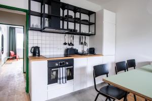 a kitchen with a stove and a table with chairs at Flattering - Berlin in Berlin