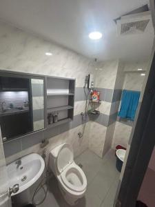 a bathroom with a toilet and a sink at Victoria Sports Tower in Manila
