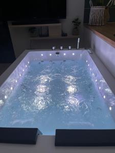 a jacuzzi tub with lights in a room at La Suite in Brie
