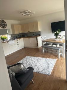 a living room with a table and a kitchen at Lavender Cottage in Oundle