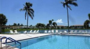 una piscina con tumbonas y palmeras en Association, Tennis Courts and Pool, Sleeps 4 - Cinnamon Cove Cozy Condo, en Fort Myers