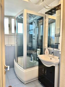 La salle de bains est pourvue d'une douche en verre et d'un lavabo. dans l'établissement The Heart Of The City - Wifi 500 mb/s, à Durrës