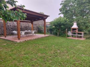a gazebo with a table and a grill in a yard at Apartaments Rurals Cala Palmira in Alpens