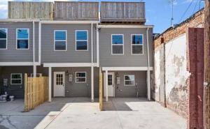 a gray building with a fence in front of it at The Blue House! Modern+ Rooftop deck+ Parking in Baltimore