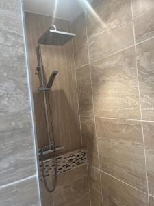 a shower with a shower head in a bathroom at Lavender Cottage in Oundle