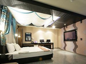 ein Schlafzimmer mit einem Bett und einem TV. in der Unterkunft JJ Hotel in Seoul