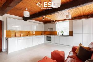 a large kitchen with white cabinets and a couch at 3 Bedroom House - Overlooking River - Shrewsbury Town Centre in Shrewsbury