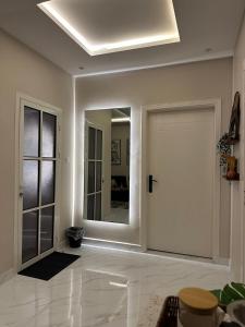 a white room with a door and a mirror at شقة مودرن في حي العقيق in Riyadh