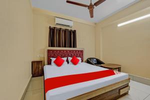 1 dormitorio con 1 cama grande con almohadas rojas en OYO Flagship 81208 Jagarnath Palace, en Ranchi