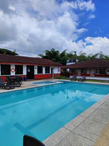 a large swimming pool in front of a building at Hotel campestre La Floresta in Armenia