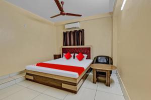 ein Schlafzimmer mit einem Bett und einem Stuhl darin in der Unterkunft OYO Flagship 81208 Jagarnath Palace in Ranchi