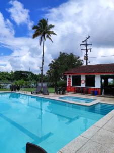 a pool with a palm tree and a building at Hotel campestre La Floresta in Armenia