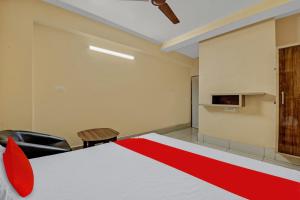 ein Zimmer mit einem Bett mit einem roten Streifen darauf in der Unterkunft OYO Flagship 81208 Jagarnath Palace in Ranchi