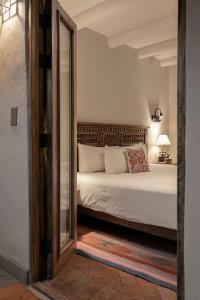 een slaapkamer met een bed en een spiegel bij Antigua Casona San Blas in Cuzco