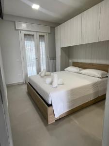 1 dormitorio con 1 cama grande con sábanas y almohadas blancas en Casa Vacanze Santa Maria en Santa Maria di Castellabate