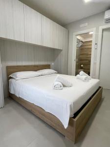 una camera da letto con un grande letto con lenzuola bianche di Casa Vacanze Santa Maria a Santa Maria di Castellabate